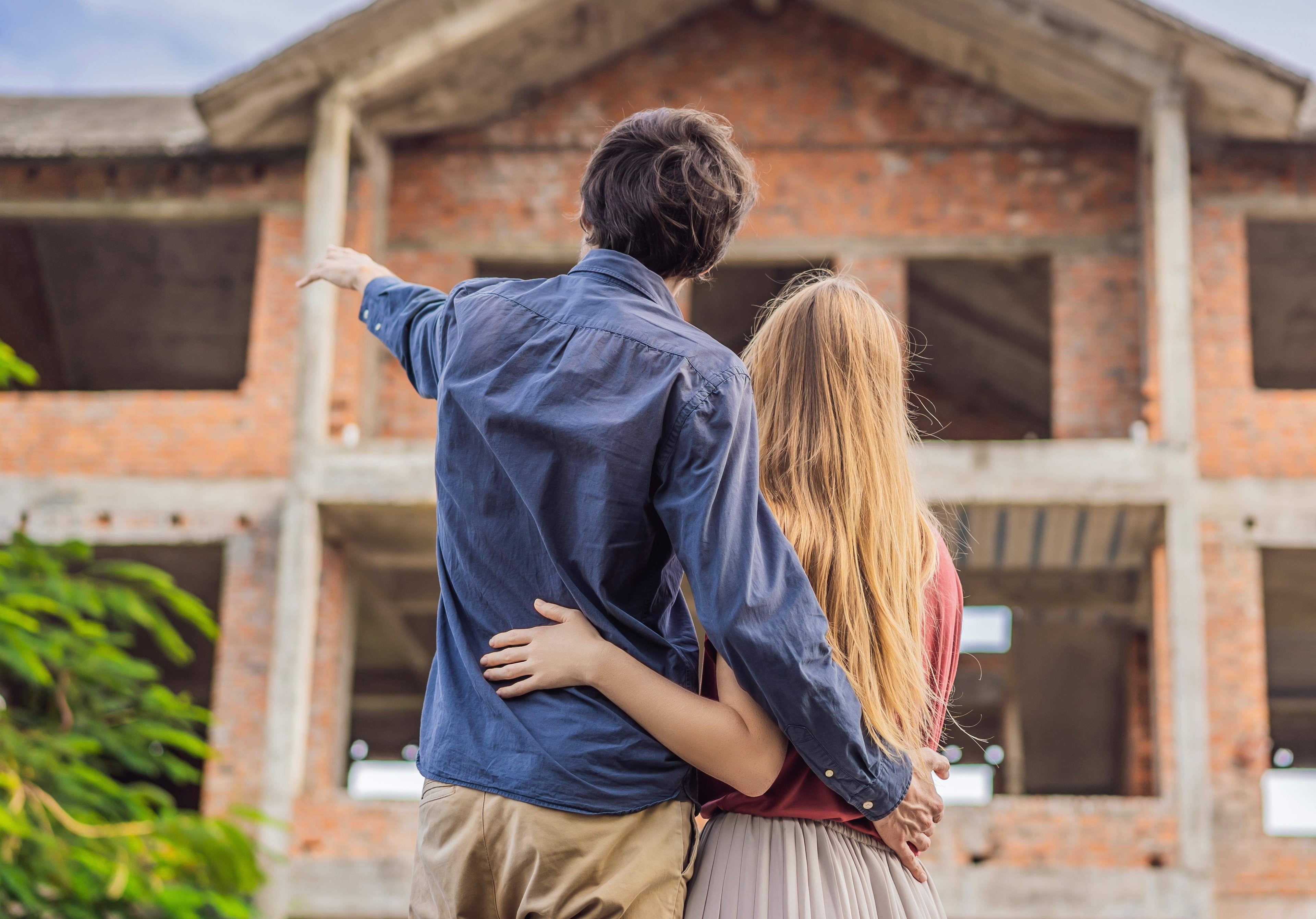 Couple,Looking,At,Their,New,House,Under,Construction,,Planning,Future